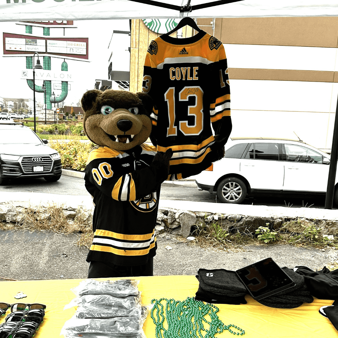 Bruins mascot blades posing in front of a signed Charlie Coyle jersey