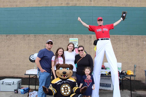 Blades the Boston Bruins mascot bear posed with a family and Big League Brian