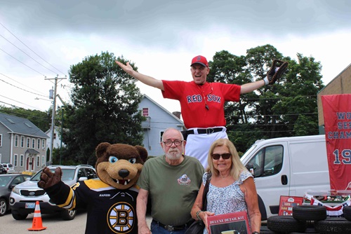 Attendants posing with Big League Brian, Boston Red Sox stilt-walker, and Boston Bruins mascot Blades