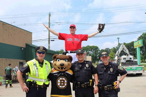 3 Dover Police posed with Boston Bruins mascot Blades the bear and Big League Brian the stilt-walker behind them.