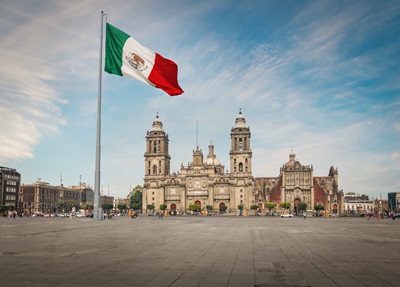 The Mexican flag flying in a city.