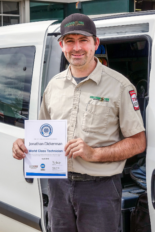 ASE World Class Technician Jon Dickerman holding his ASE Certification Certificate