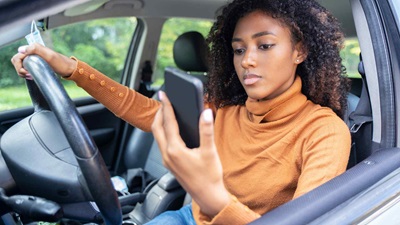 A driver looking at their smartphone