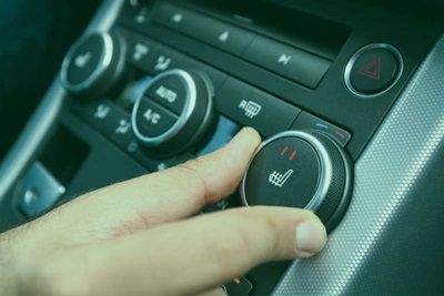Image of someone turning the heat dial in their vehicle
