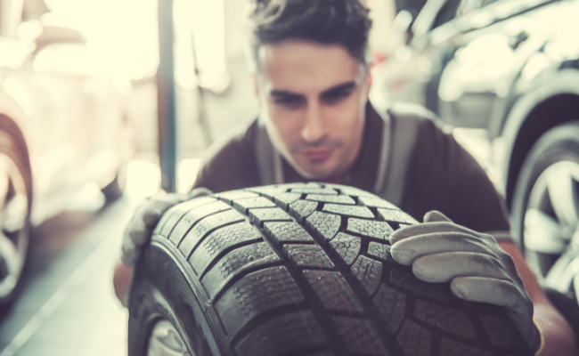 Man examining tire tread
