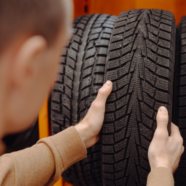 Man looking at tire tread pattern