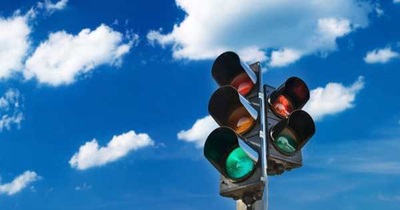 Modern traffic light against a cloudy blue sky
